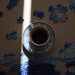 Artistic shot of coffee cup on a Van Gogh puzzle, illuminated by soft light.